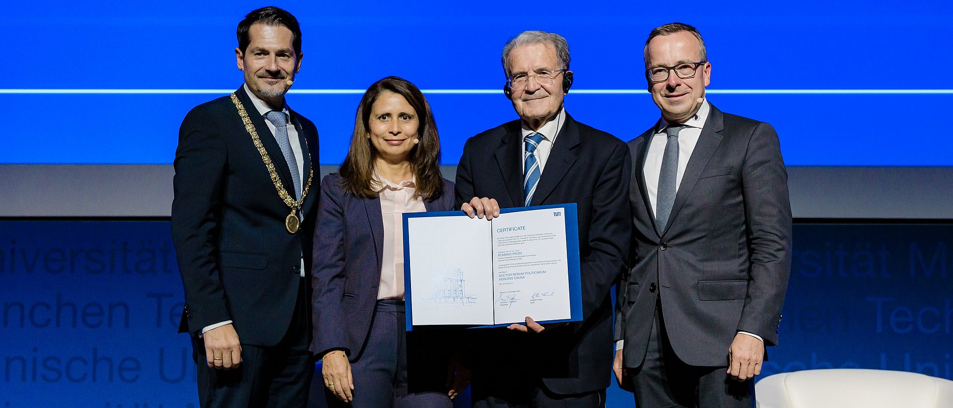 Romano Prodi with TUM President Thomas F. Hofmann (l.), Dean Gunther Friedl (r.), and Eugénia da Conceição-Heldt on stage in the audimax lecture hall.