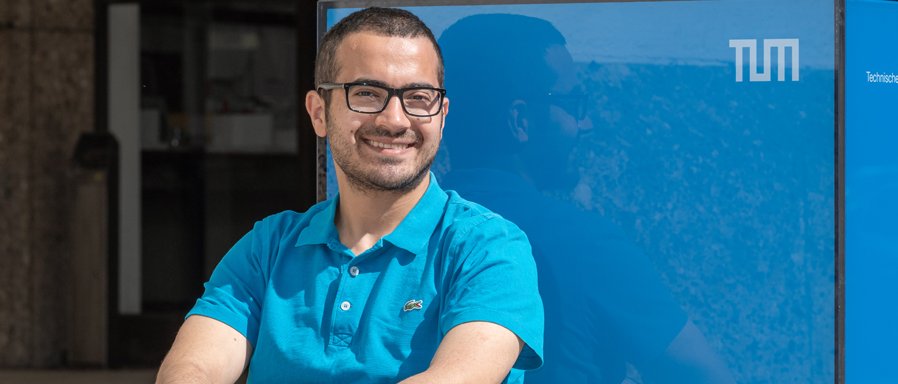 Hussein Al Ammawi in front of a blue cube