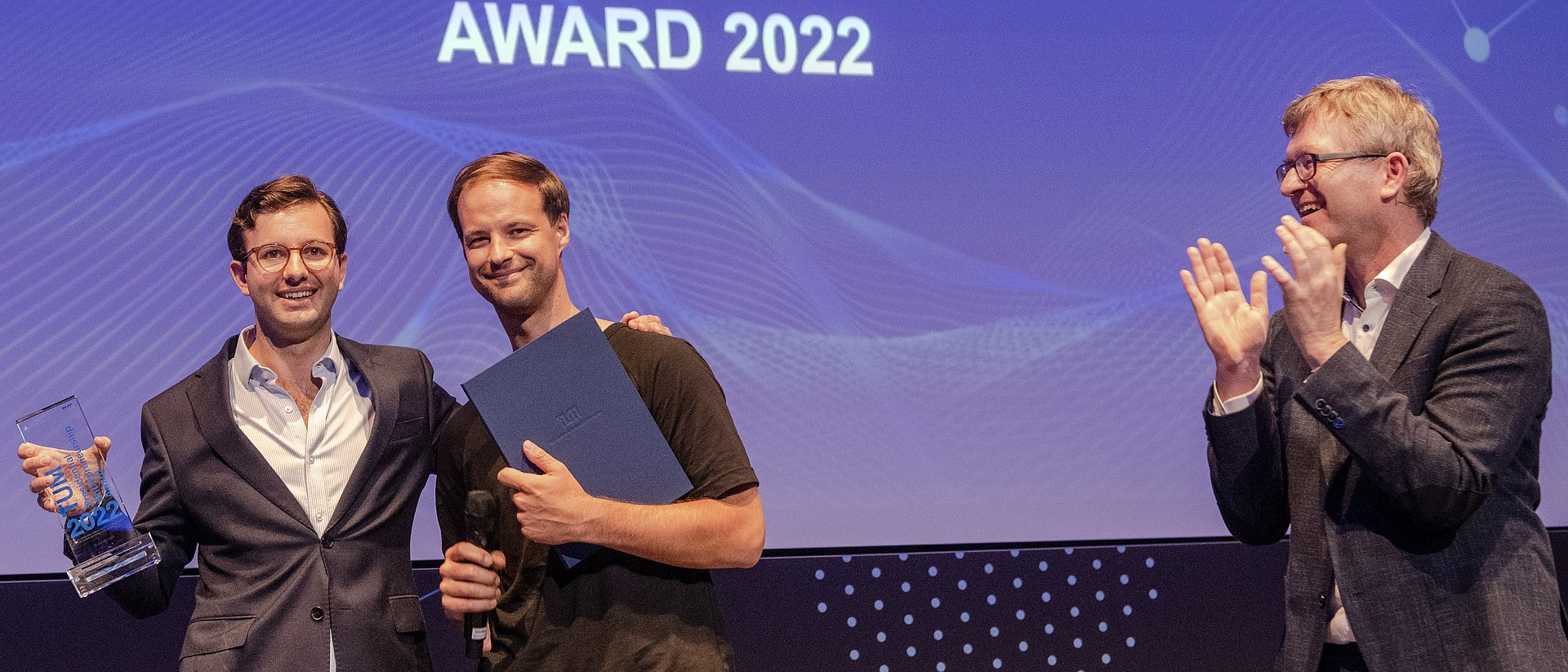 Helmut Schönenberger, Vice President for Entrepreneurship, congratulates Manuel Thurner and Konstantin Mehl of Kaia Health Software.