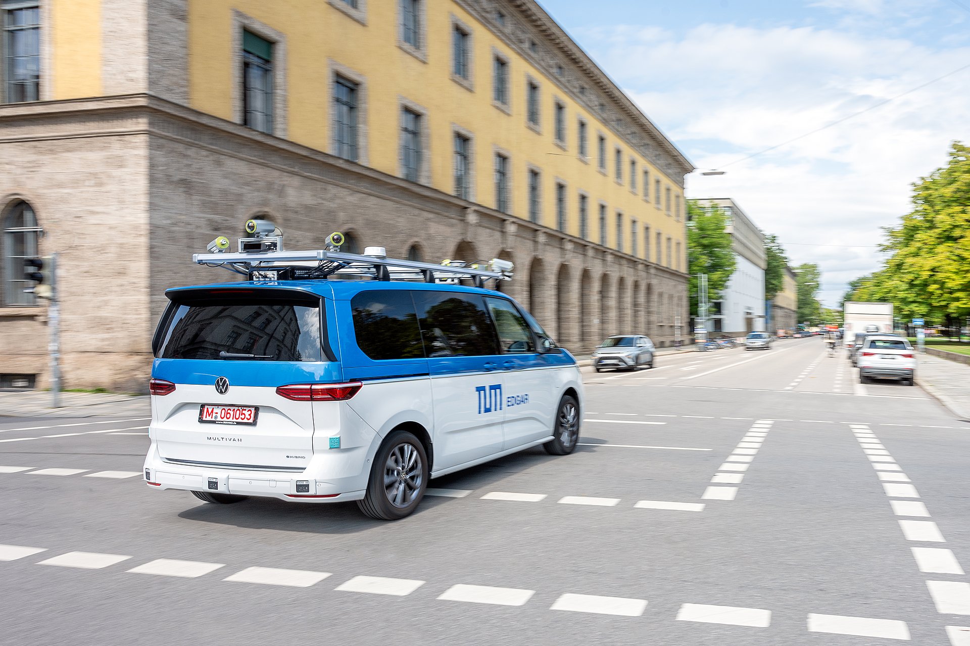 A minibus with roof attachments and sensor technology for autonomous driving drives through Munich.