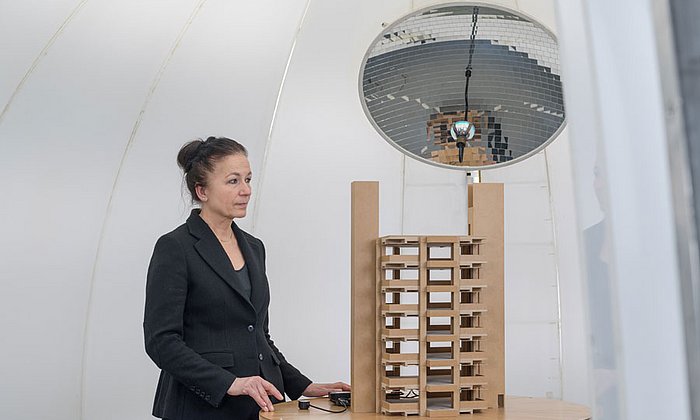 Prof. Hannelore Deubzer mit Architekturmodell in der Lichtkuppel zur Simulation von Tageslicht. (Bild: Andreas Heddergott / TUM)