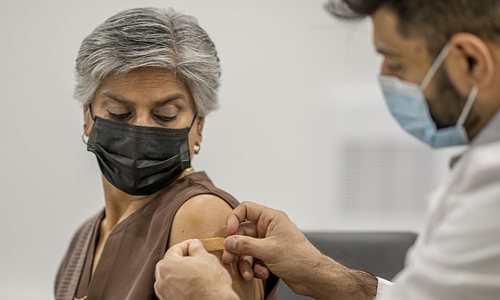 A woman gets vaccinated by a doctor