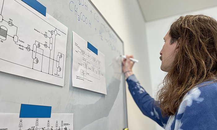 A scientist at a whiteboard writing formulas