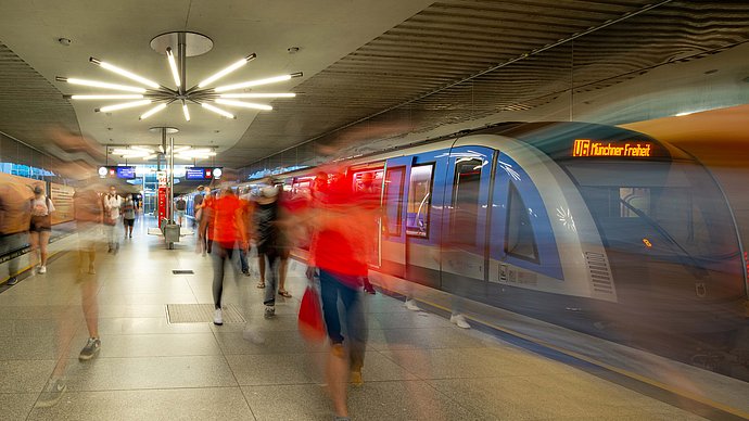 U-Bahnhof Garching-Forschungszentren: Fahrgäste steigen aus der U-Bahn U6 aus und laufen über den Bahnsteig. Starke Bewegungsunschärfe.