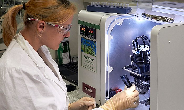 Erstautorin Catharina Kober mit dem LegioTyper-Chip. (Foto: Jonas Bemetz / TUM)