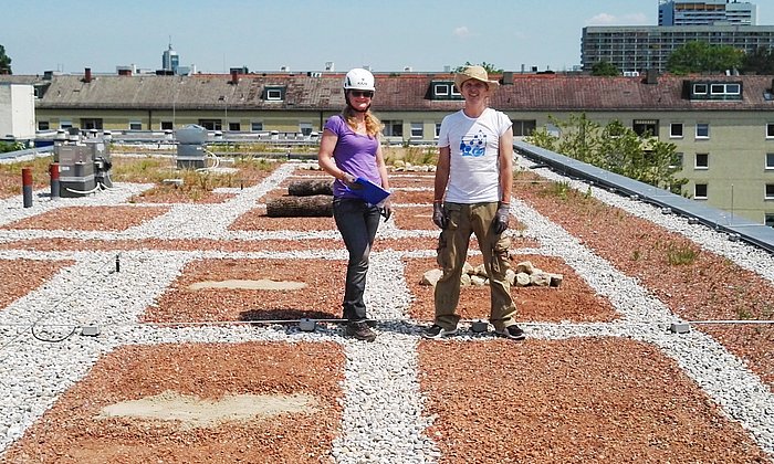 Claudia Seilwinder und Sebastian Meyer auf dem bekiesten Flachdach eines TUM-Gebäudes.