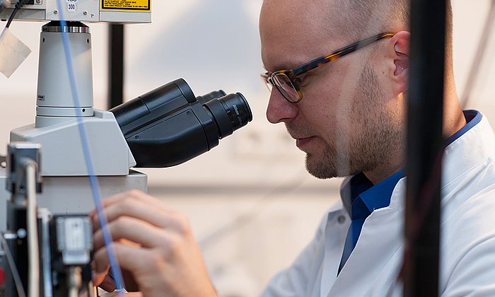 Marc Aurel Busche am Zwei-Photonen-Mikroskop, welches die direkte Beobachtung von Nervenzellen im intakten Gehirn mit hoher räumlicher und zeitlicher Auflösung ermöglicht. (Bild: K. Bauer / TUM)