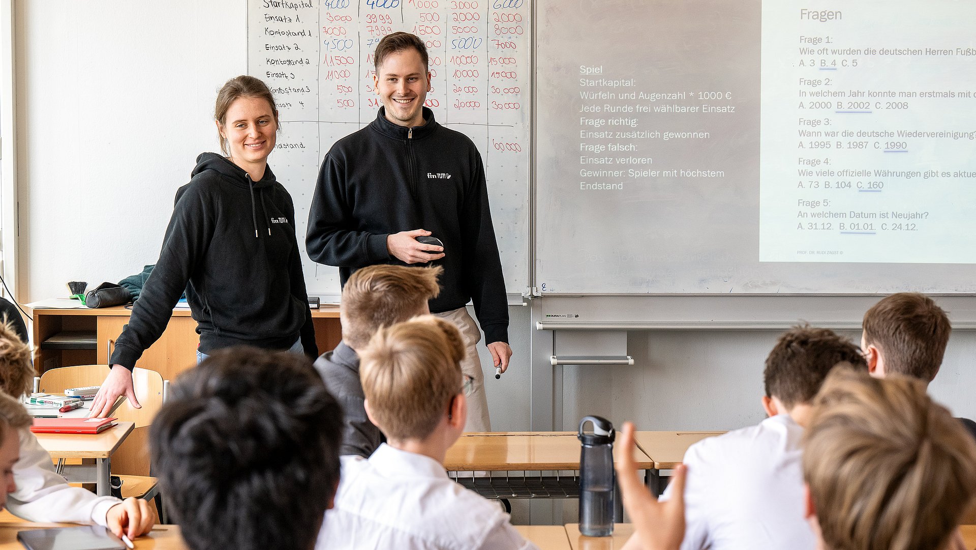 Studierende bringen Schüler:innen in dem Workshop "Because we care" einen verantwortungsvollen Umgang mit Geld bei