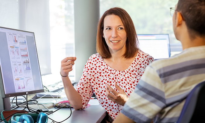 Professorin Melanie Schirmer diskutiert mit einem Forscher.