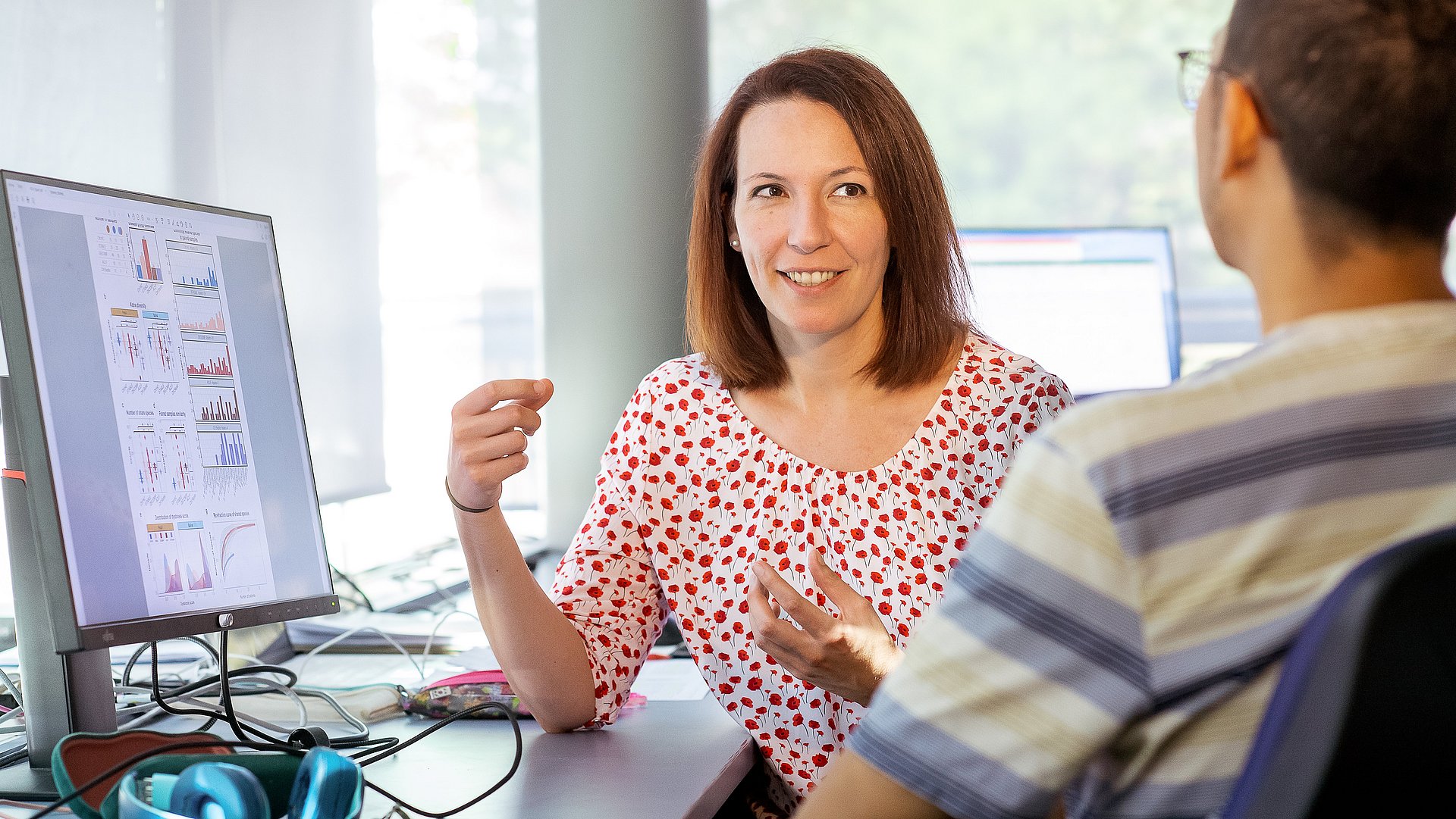 Prof. Dr. Melanie Schirmer Professorin Melanie Schirmer diskutiert mit einem Forscher.