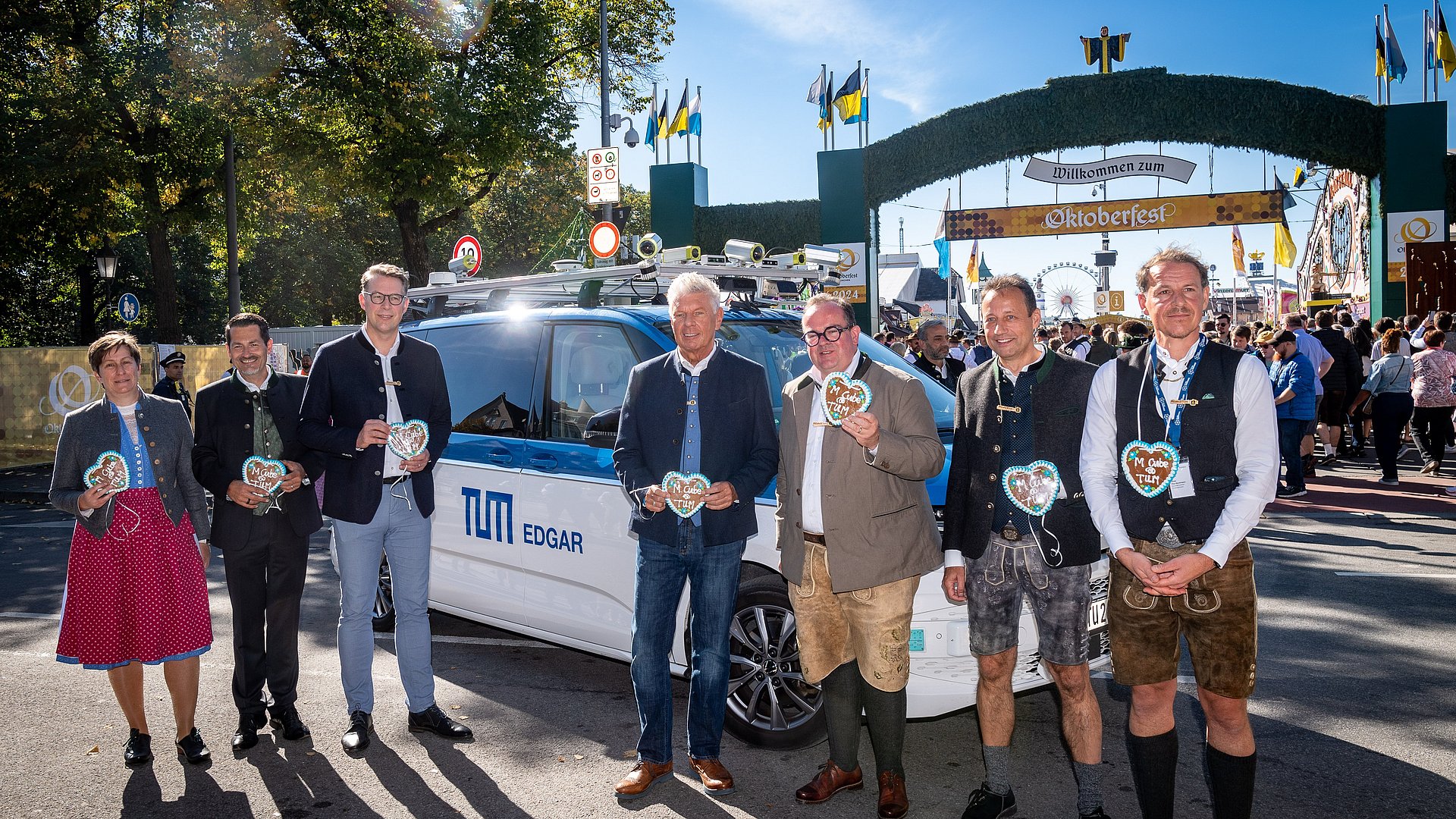 EDGAR, sogenanntes Autonomes Wiesn Shuttle, PK mit Minister Blume, OB Reiter, Präsident Hofmann u. Baumgärtner: Foto: Andreas Heddergott /TUM; Verwendung frei für die Berichterstattung über die TUM bei Nennung des Copyrights /Free for use in reporti Geladene Gäste vor dem Wiesn Shuttle, im Hintergrund ist das Oktoberfest zu sehen