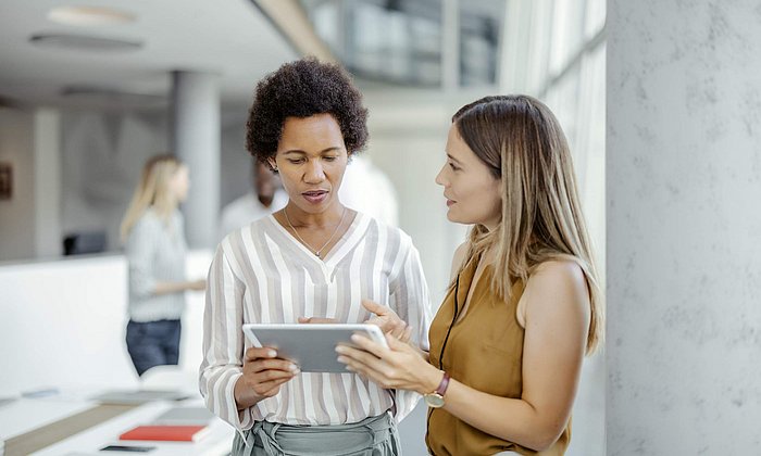 Two female managing directors discussing project ideas over a touch pad  - image: iStock 