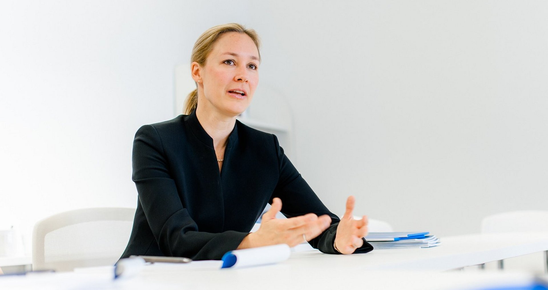 Prof. Claudia Peus sitzt am Tisch und spricht.