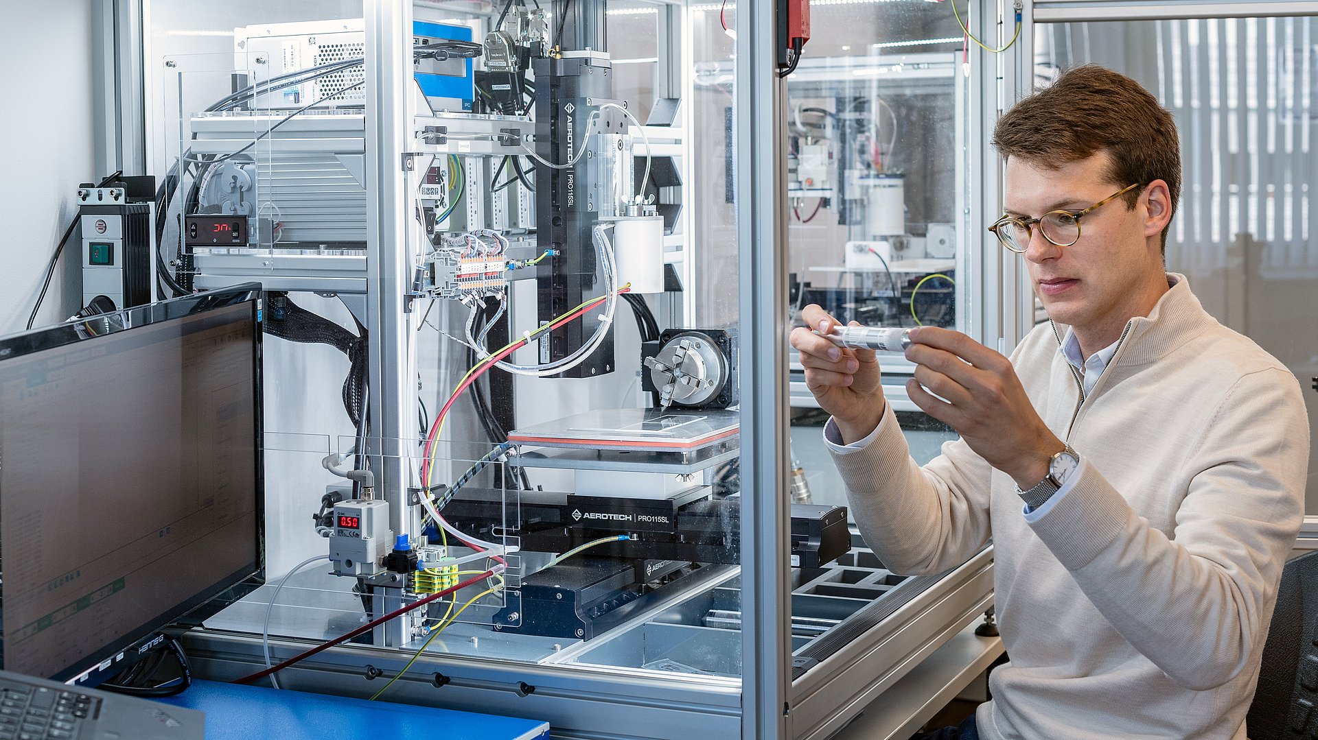 Kilian Mueller, Doktorand an der TUM School of Engineering and Design,begutachtet eine 3D gedruckte Herzklappenstruktur, die in einer Melt Electrowriting (MEW) Anlage gefertigt wurde. 
