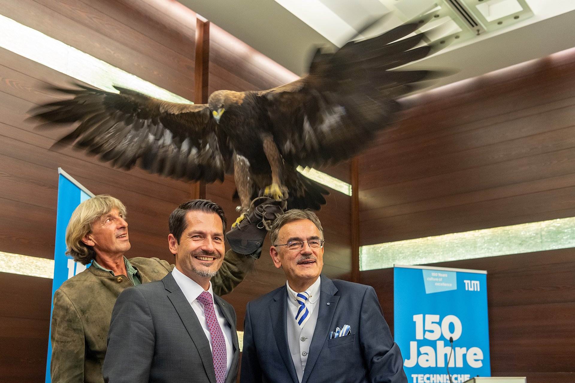 Falkner Wolfgang Czech zeigt Prof. Dr. Wolfgang A. Herrmann, Präsident der TUM, und Prof. Dr. Thomas Hofmann, designierter Präsident der TUM, den Steinadler Jenny.