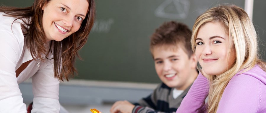 Eine Lehrerin mit zwei Schülern im Klassenzimmer