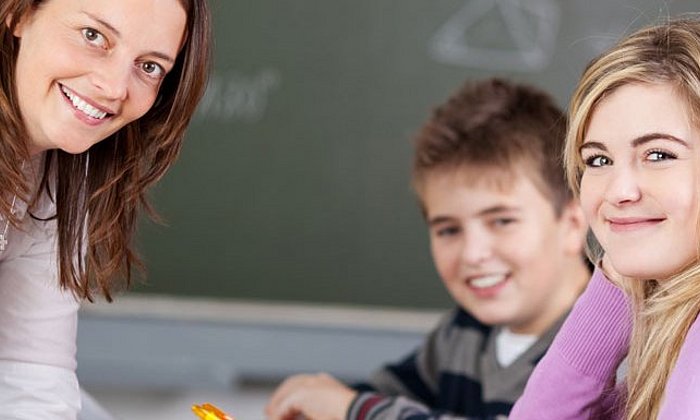 Eine Lehrerin mit zwei Schülern im Klassenzimmer