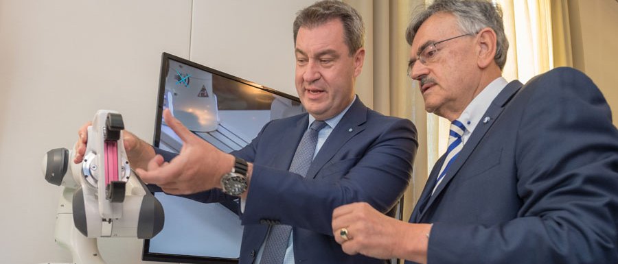TUM President Wolfgang A. Herrmann (r.) shows Minister President Markus Söder a robotic arm designed to help physiotherapists in their work. (photo: A. Heddergott / TUM; video: Bavarian State Chancellery)