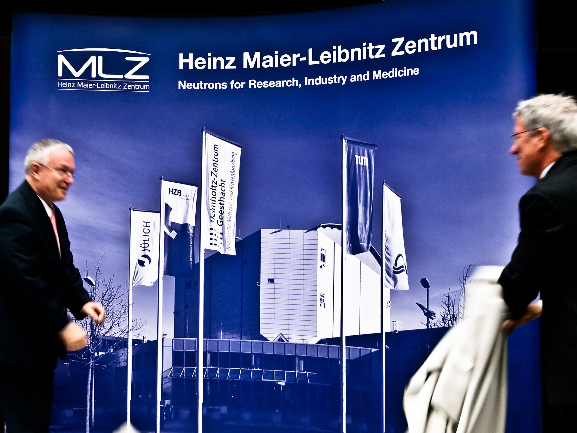 Prof. Dieter Richter, Forschungszentrum Jülich (links) und Prof. Winfried Petry, FRM II, (rechts) enthüllen das neue Logo des Heinz Maier-Leibnitz Zentrums - Foto: Ina Lommatzsch / TUM