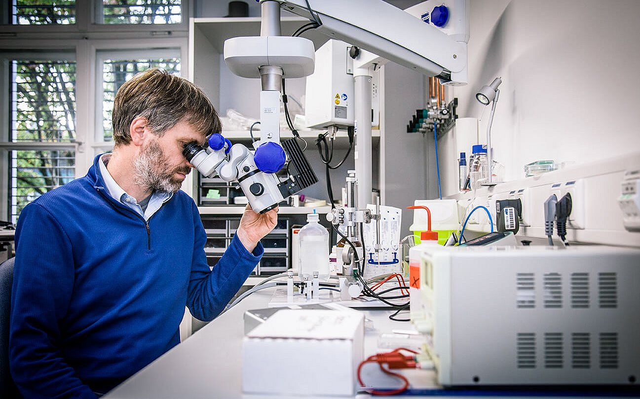 Prof. Thomas Misgeld blickt in ein Mikroskop