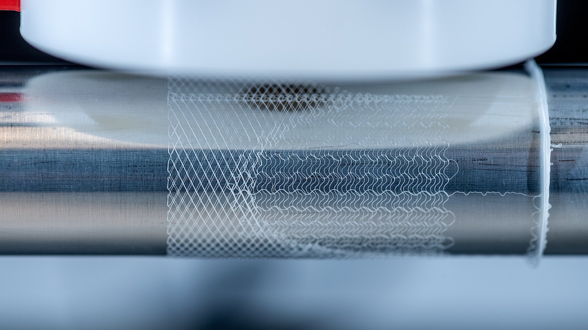 Close-up of a cylinder in a Melt Electrowriting system showing a printed heart valve scaffold. 