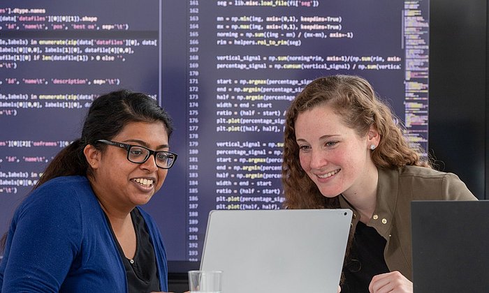 Zwei Forscherinnen besprechen an einem Laptop ihre Daten im Zentrum für translationale Krebsforschung der TUM (TranslaTUM).