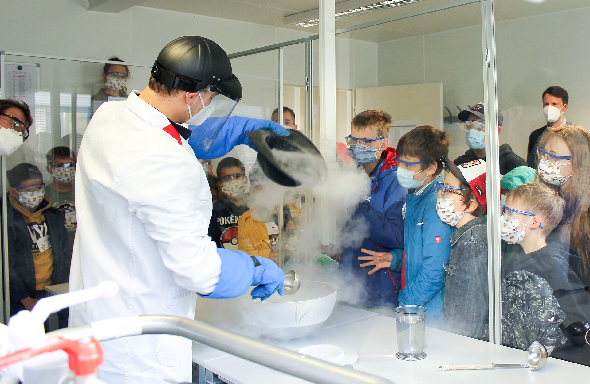 In the laboratory, PhD student Tobias Neuwirth makes ice cream using nitrogen under the attentive observation of children.