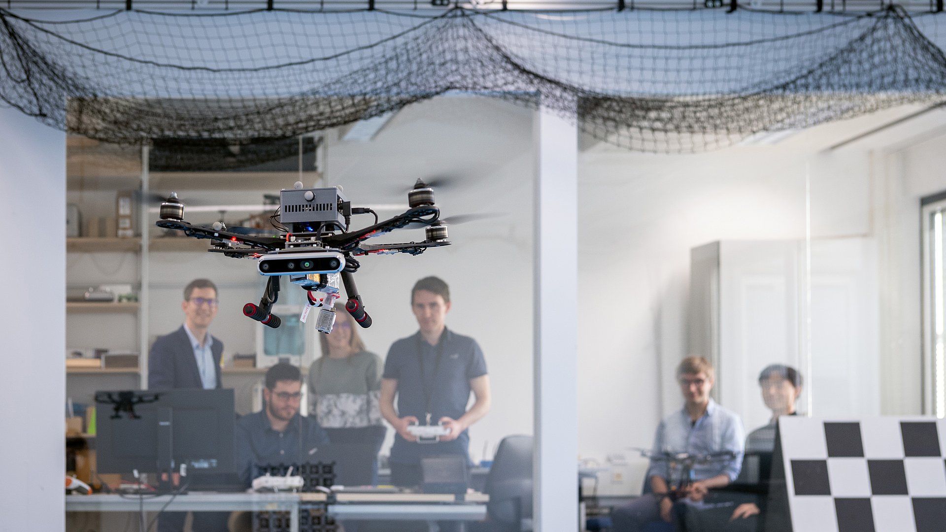 Prof. Stefan Leutenegger (left) and his team of researchers test a drone in the lab.