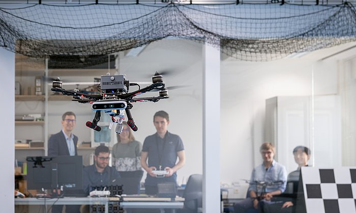 Prof. Stefan Leutenegger (left) and his team of researchers test a drone in the lab.