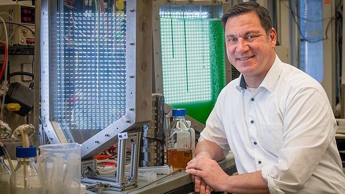 Werner Siemens-Lehrstuhl für Synthetische Biotechnologie (WSSB); Prof. Dr. Thomas Brück; Green Carbon aud Algenöl; Foto: Andreas Heddergott /TUM; Verwendung frei für die Berichterstattung über die TUM bei Nennung des Copyrights /
Free for use in rep Ein Mann sitzt auf einem Laborstuhl vor einer Arbeitsplatte. Vor ihm steht eine Spule mit grau-silbernem Material. Außerdem ist ein grün leuchtender Tank zu sehen.
