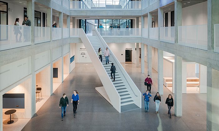 Studierende gehen durch die Halle im Neubau der Fakultät für Elektrotechnik und Informationstechnik der TUM am Campus Garching (Bild: Andreas Heddergott / TUM).