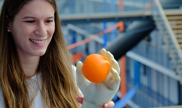 Doktorandin Johanna Happold zeigt, wie eine Handprothese mithilfe von Muskelsignalen greift.