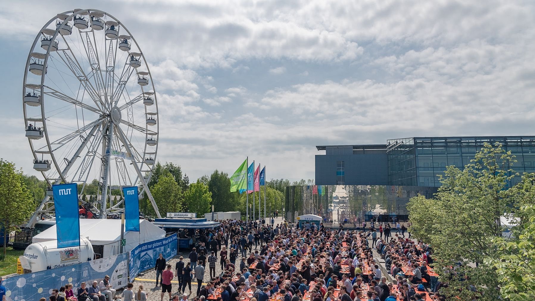 Ferris wheel and beer tables with guests at the “maiTUM” festival on the Garching campus to celebrate the anniversary year 2018.