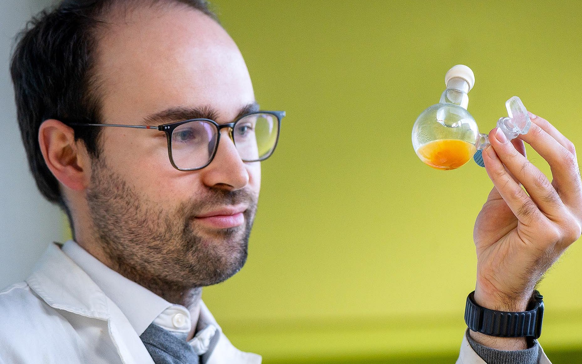 Dr. Philip Stanley kontrolliert einen Kolben, in dem sich das neue Material in einer wässrigen Lösung befindet.