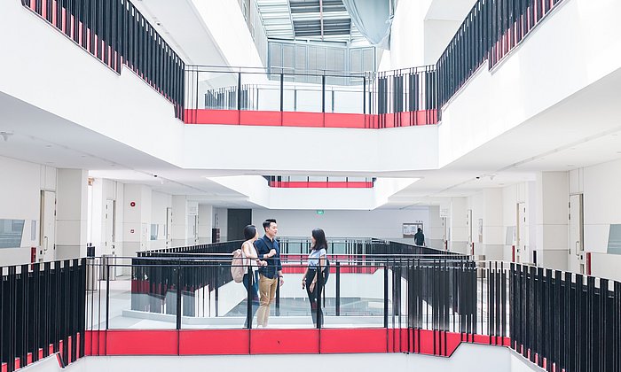 Two students are chatting in a stairwell. 