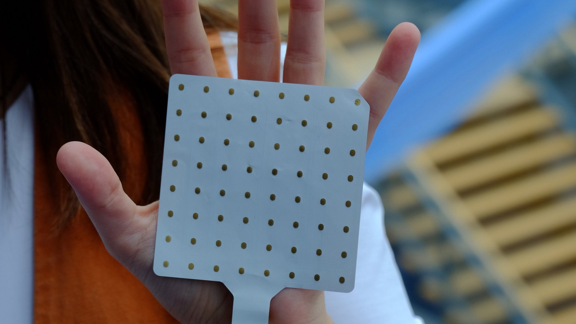 Scientist Dr Patricia Capsi-Morales shows the slide with 64 sensors that she uses for her research.