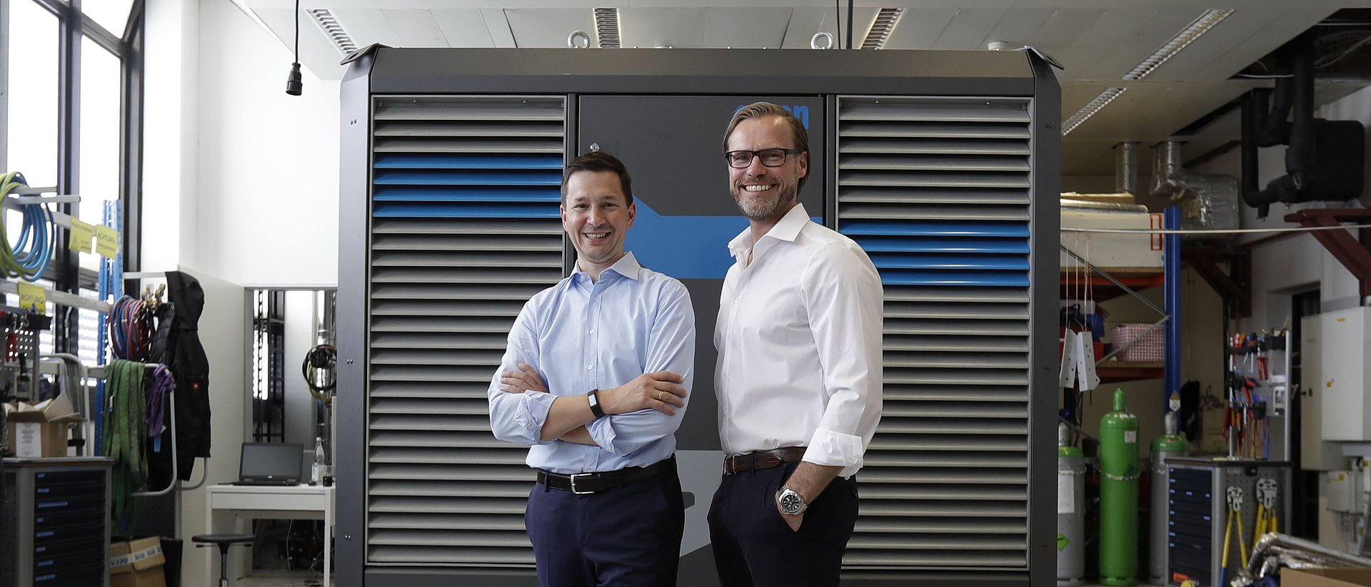 Andreas Sichert and Wolfgang Brand, executive directors of Orcan Energy, in front of their product, which produces electricity from waste heat.