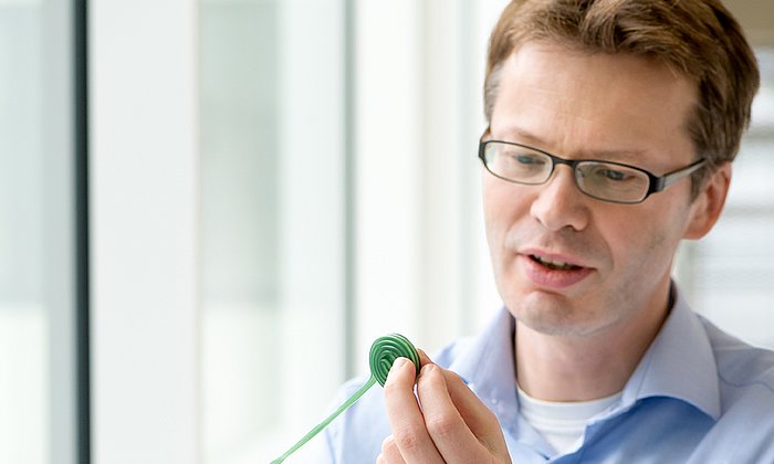 Together with his team Prof. Mikael Simons researches the formation and removal of the myelin sheathes which surround nerve fibers and which are destroyed in Multiple Sclerosis. Here he uses a licorice roll to illustrate the appearance of the sheathes. (Photo: A. Eckert / TUM)