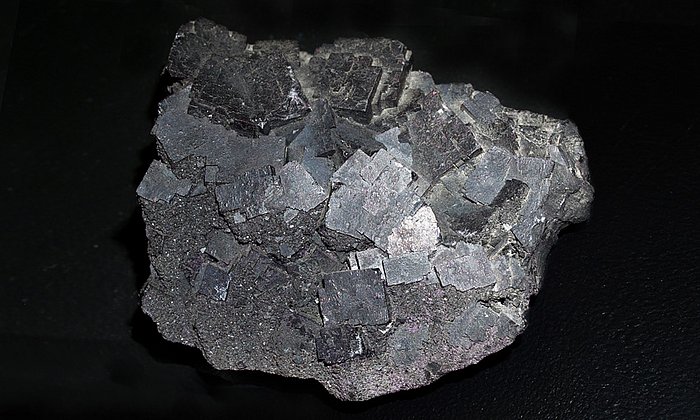 Das Bild zeigt dunkel-violette bis schwarze Kristalle des "Stinkspats".