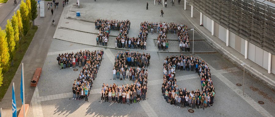 Menschen formen den Schriftzug "TUM 150"