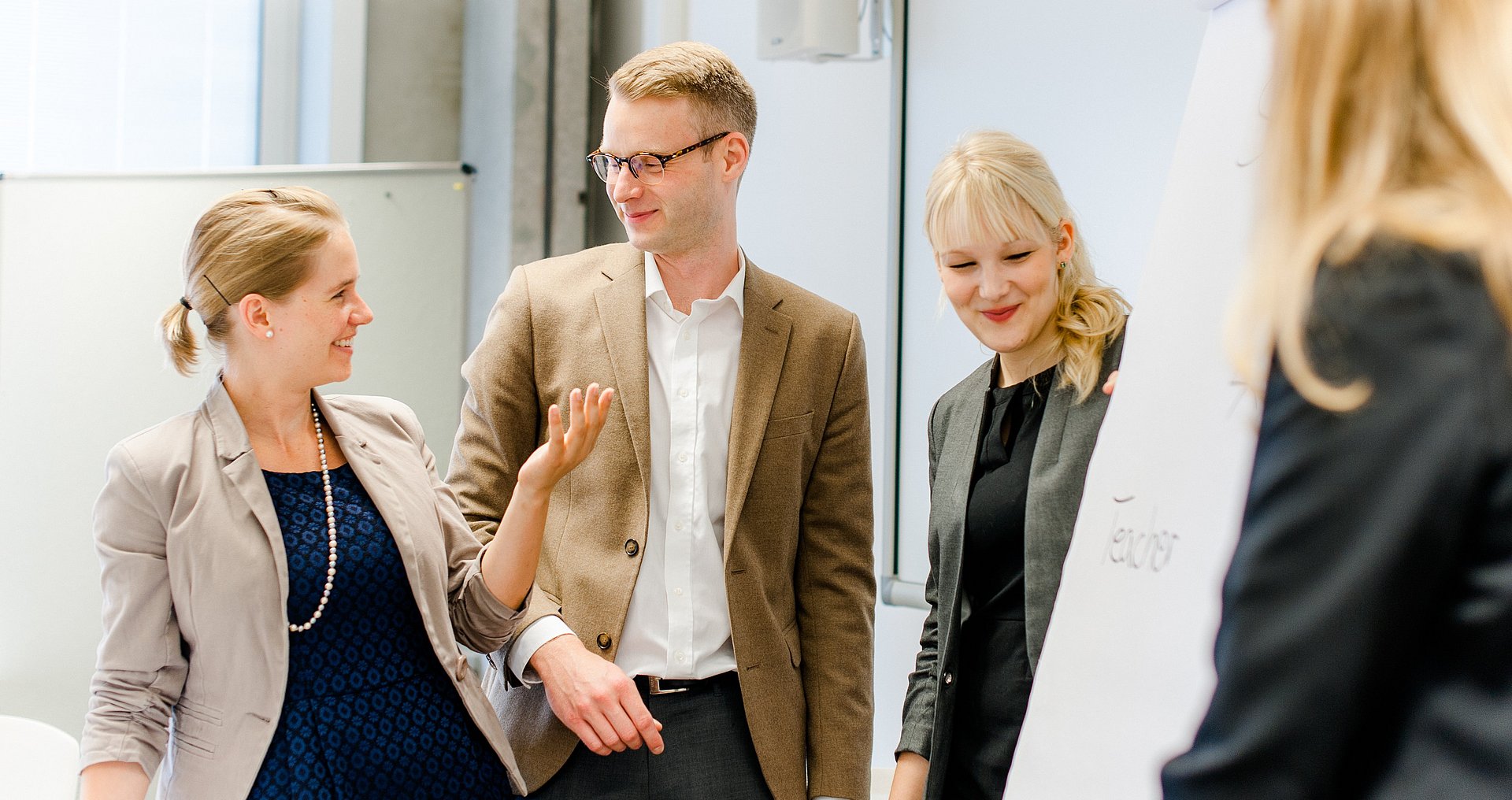 Group of people exchange ideas in front of flipchart.