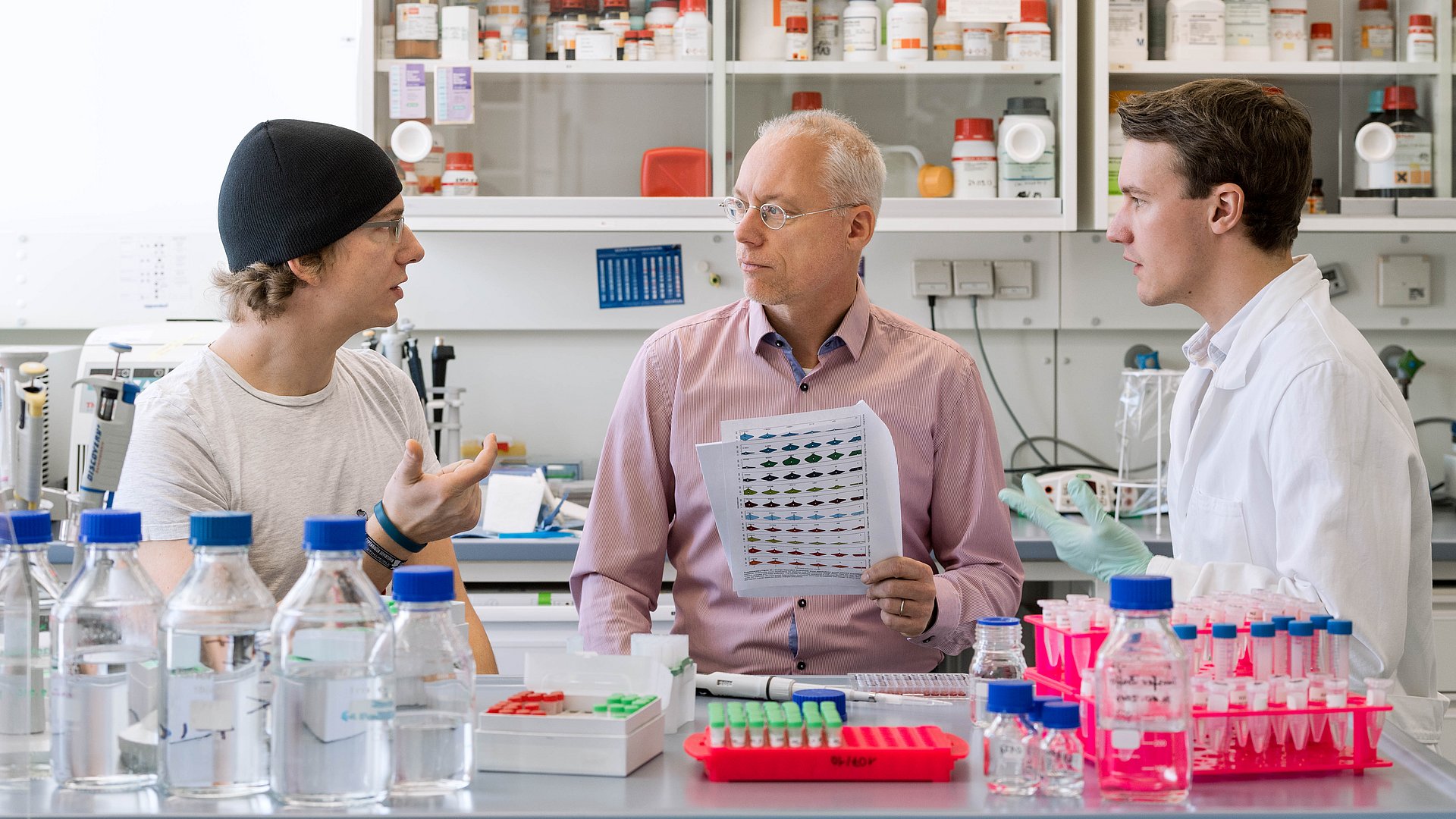 Mathias Wilhelm, Professor Bernhard Küster and Daniel Paul Zolg (f.l.t.r.) in discussion about the ProteomeTools Peptide Library called PROPEL. (Photo: Andreas Heddergott/ TUM)