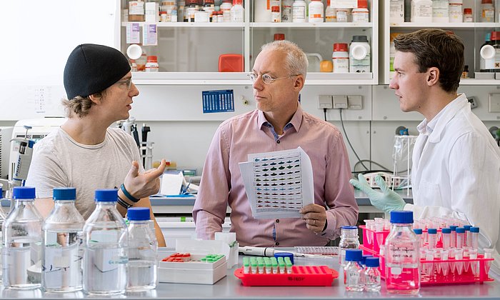 Mathias Wilhelm, Professor Bernhard Küster and Daniel Paul Zolg (f.l.t.r.) in discussion about the ProteomeTools Peptide Library called PROPEL. (Photo: Andreas Heddergott/ TUM)