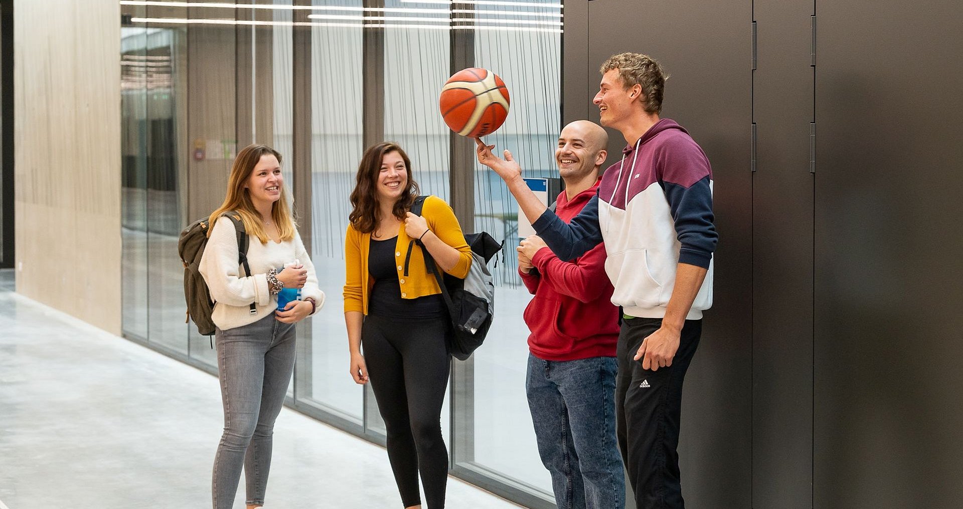 Studierende stehen in einer Gruppe und spielen mit einem Ball