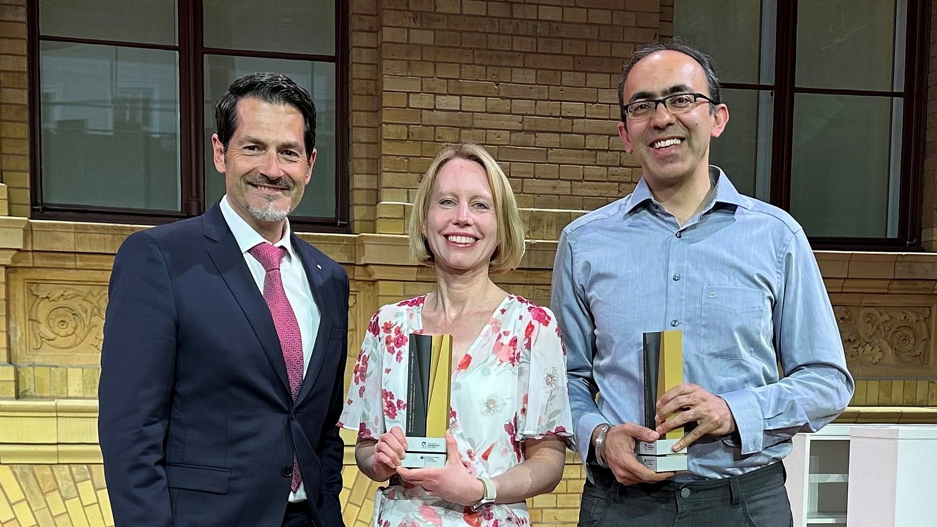 TUM President Thomas Hofmann with Stefanie Jegelka and Suvrit Sra