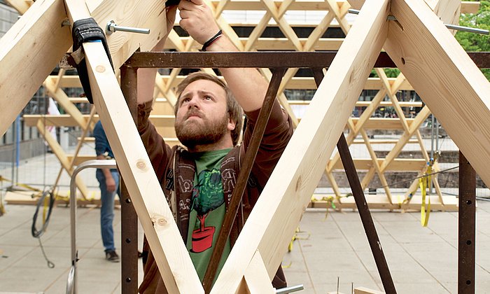 Architektur-Student Mattia Zucco bei der Arbeit am Zollinger-Lamellendach vor dem Nordgebäude der TU München