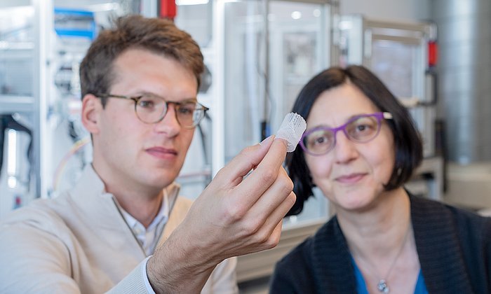 Petra Mela, Professor of Medical Materials and Implants at the Technical University of Munich (TUM) and doctoral candidate Kilian Meuller examine an artificial heart valve produced with the additive manufacturing technology melt electrowriting.