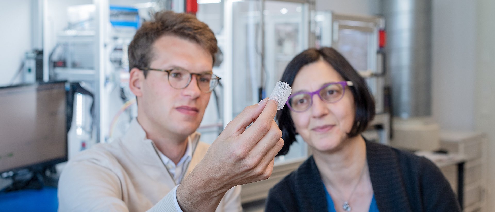 Petra Mela, Professor of Medical Materials and Implants at the Technical University of Munich (TUM) and doctoral candidate Kilian Meuller examine an artificial heart valve produced with the additive manufacturing technology melt electrowriting.