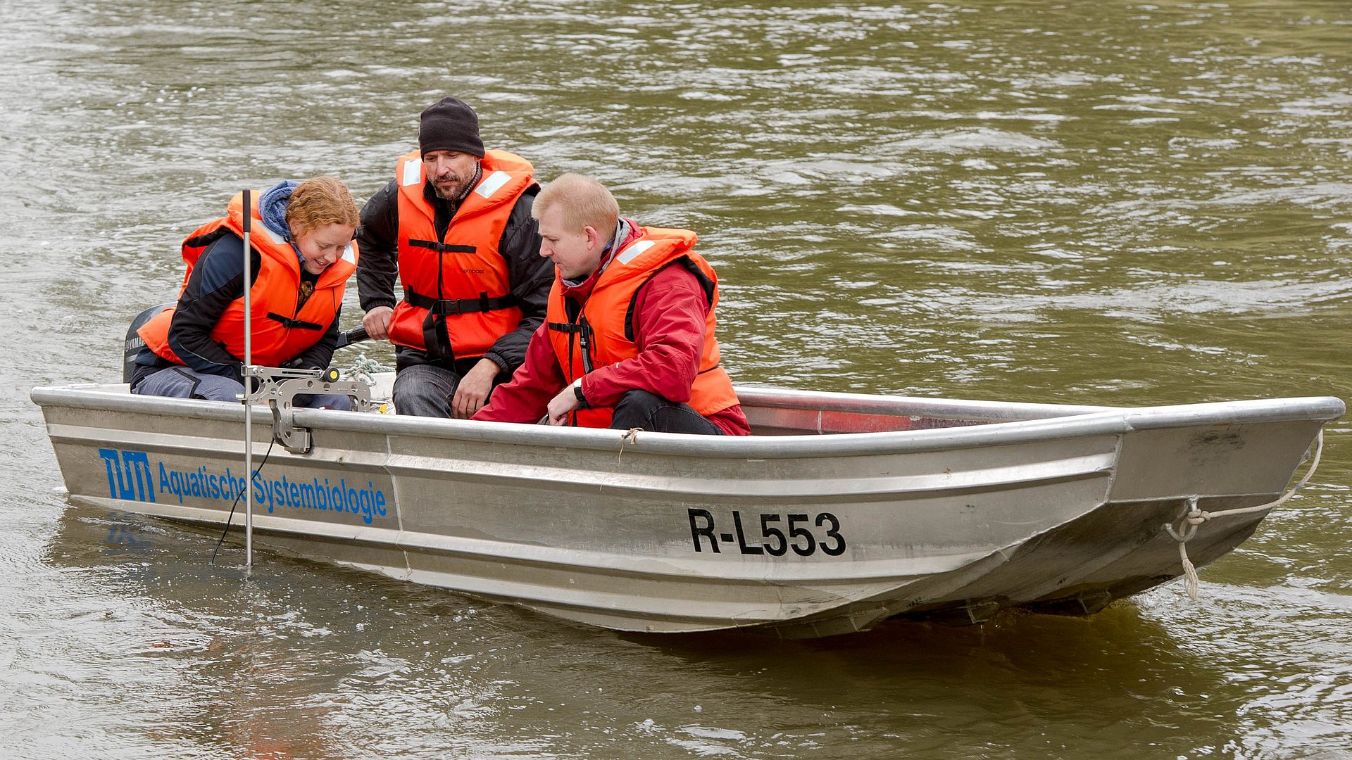 Dr. Melanie Müller, Dr. Joachim Pander und Prof. Jürgen Geist in einem Forschungsboot auf einem Fluss.   