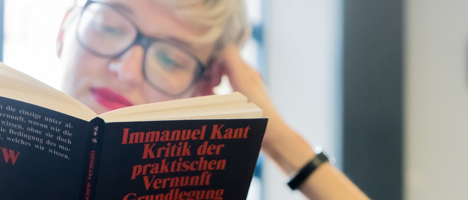 Student reading a book of Immanuel Kant